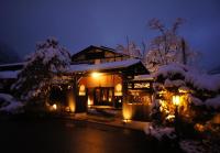a house covered in snow at night with lights at Hidaji (Adult Only) in Takayama