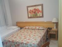 a bedroom with a bed and a picture of flowers at Hotel Vila do Conde in Itu