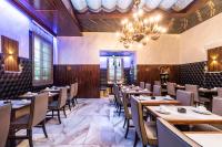 a restaurant with wooden tables and chairs and a chandelier at Hotel Abbazia in Venice