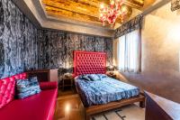 a bedroom with a red bed and a couch at Hotel Abbazia in Venice