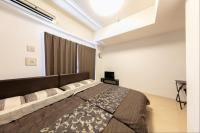 Un dormitorio con una cama grande y una ventana. en Eight Residence Osaka, en Osaka