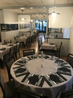 Le Relais De La Place في Le Faou: غرفة طعام مع طاولات وكراسي مع كاسات