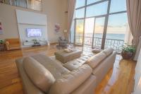 Una sala de estar con un sofá y una ventana grande. en Sotis Hotel Kupang, en Kupang