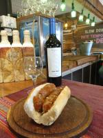 uma garrafa de vinho e um sanduíche sobre a mesa em Del Glaciar Libertador Hotel em El Calafate