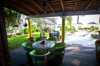 uma mesa e cadeiras num alpendre com um guarda-sol em Hotel Gilda em Coyuca