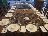 クアにあるHIG ホテルの白い皿と銀器が置かれた長テーブル