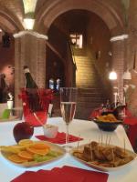 a table with a plate of food and a glass of wine at Palazzetto Rosso - Art Hotel in Siena