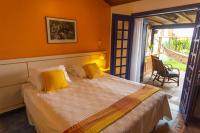 a bedroom with a large bed with yellow pillows at Pousada DiMari in Boicucanga