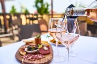 een persoon die wijn in een glas giet op een tafel bij Hotel Babylon Heerhugowaard - Alkmaar in Heerhugowaard