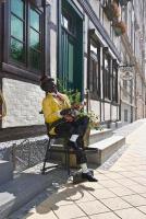 a man sitting on a chair on a street at Pension Karina Schwerin in Schwerin