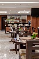 um restaurante com mesas e cadeiras com taças de vinho em Firenze Business Hotel em Palhoça