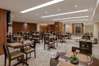 um restaurante com mesas e cadeiras em uma sala em Firenze Business Hotel em Palhoça