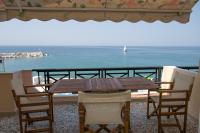 a wooden table and chairs on a balcony with the ocean at ELVETIA VILLA in Potos