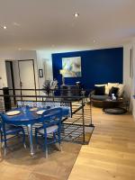 a living room with a blue table and a couch at Les Suites de Bougainville in Concarneau