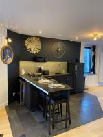 a kitchen with a table and a black wall at Les Suites de Bougainville in Concarneau