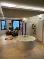 a large bathroom with a tub in the middle of a room at Les Suites de Bougainville in Concarneau