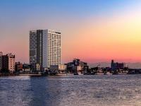 a city skyline with a tall building and the water at 쏘타스위트 속초 월드스테이트 in Sokcho