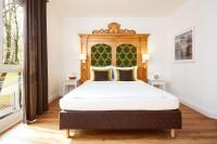 Una cama con cabecero de madera en una habitación. en Hotel Prinzregent München Messe, en Múnich
