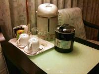 a table with a tea pot and cups on it at The Premier Hotel in Tainan