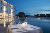 a table with wine glasses next to a swimming pool at Terme di Saturnia Natural Spa & Golf Resort - The Leading Hotels of the World in Saturnia