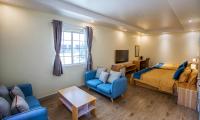 Un dormitorio con una cama, un sofá y un televisor. en Residence Lodge, en Saipán