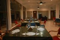 een eetkamer met lange tafels met borden en stoelen bij Balishira Resort Ltd. in Sreemangal