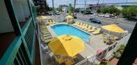 einen Pool mit Stühlen und Sonnenschirmen auf einem Balkon in der Unterkunft Shangri-La Motel in Ocean City