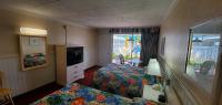 ein Hotelzimmer mit zwei Betten und einem Fernseher in der Unterkunft Shangri-La Motel in Ocean City
