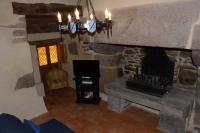 a living room with a stone fireplace and a couch at Gîte 3 pers Jacuzzi extérieur sous bulle, possibilité table d&#39;hôtes le soir in Tréduder