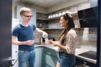 a man and a woman standing in a kitchen at WIROtel Warnemünde in Warnemünde