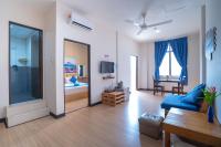 a large living room with a blue couch and a bedroom at Paretto Seaview Hotel in Pantai Cenang