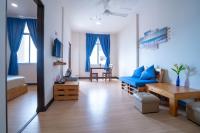 a living room with a blue couch and a table at Paretto Seaview Hotel in Pantai Cenang