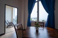 a dining room table with a vase of flowers on it at Paretto Seaview Hotel in Pantai Cenang