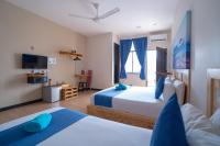 a hotel room with two beds and a television at Paretto Seaview Hotel in Pantai Cenang