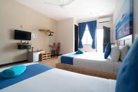 a hotel room with two beds and a television at Paretto Seaview Hotel in Pantai Cenang