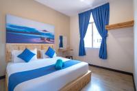 a bedroom with a large bed with blue curtains at Paretto Seaview Hotel in Pantai Cenang