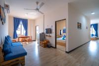 a living room with a blue couch and a bedroom at Paretto Seaview Hotel in Pantai Cenang