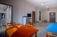 a kitchen and dining room with a table and a refrigerator at Paretto Seaview Hotel in Pantai Cenang