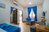 a bedroom with a blue bed and a blue chair at Paretto Seaview Hotel in Pantai Cenang