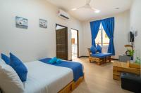 a bedroom with a king sized bed and a chair at Paretto Seaview Hotel in Pantai Cenang