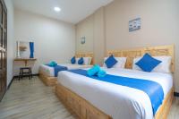 a bedroom with two beds with blue pillows at Paretto Seaview Hotel in Pantai Cenang
