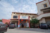 a building with cars parked in a parking lot at Paretto Seaview Hotel in Pantai Cenang