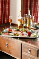 a buffet with two plates of food and glasses of wine at Tertin Kartano in Mikkeli