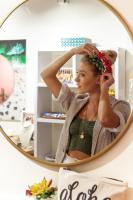 a woman adjusting her hair in front of a mirror at VIVE Hotel Waikiki in Honolulu