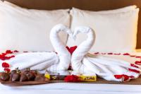two white swans making a heart shape on a bed at VIVE Hotel Waikiki in Honolulu