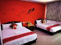 a bedroom with two beds and a red wall at Nandian Homestay in Eluan