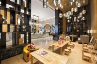 Una tienda con mesas y sillas de madera y una biblioteca. en Crowne Plaza - Kunming Ancient Dian Town by IHG, en Kunming