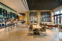 Un restaurante con suelos de madera, mesas y sillas. en Crowne Plaza - Kunming Ancient Dian Town by IHG, en Kunming