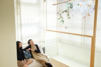 two women sitting on a couch in a room with a window at SSS Life Hotel in Tainan