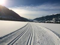 a snow covered road with tire tracks in the snow at Almwirt in Bramberg am Wildkogel